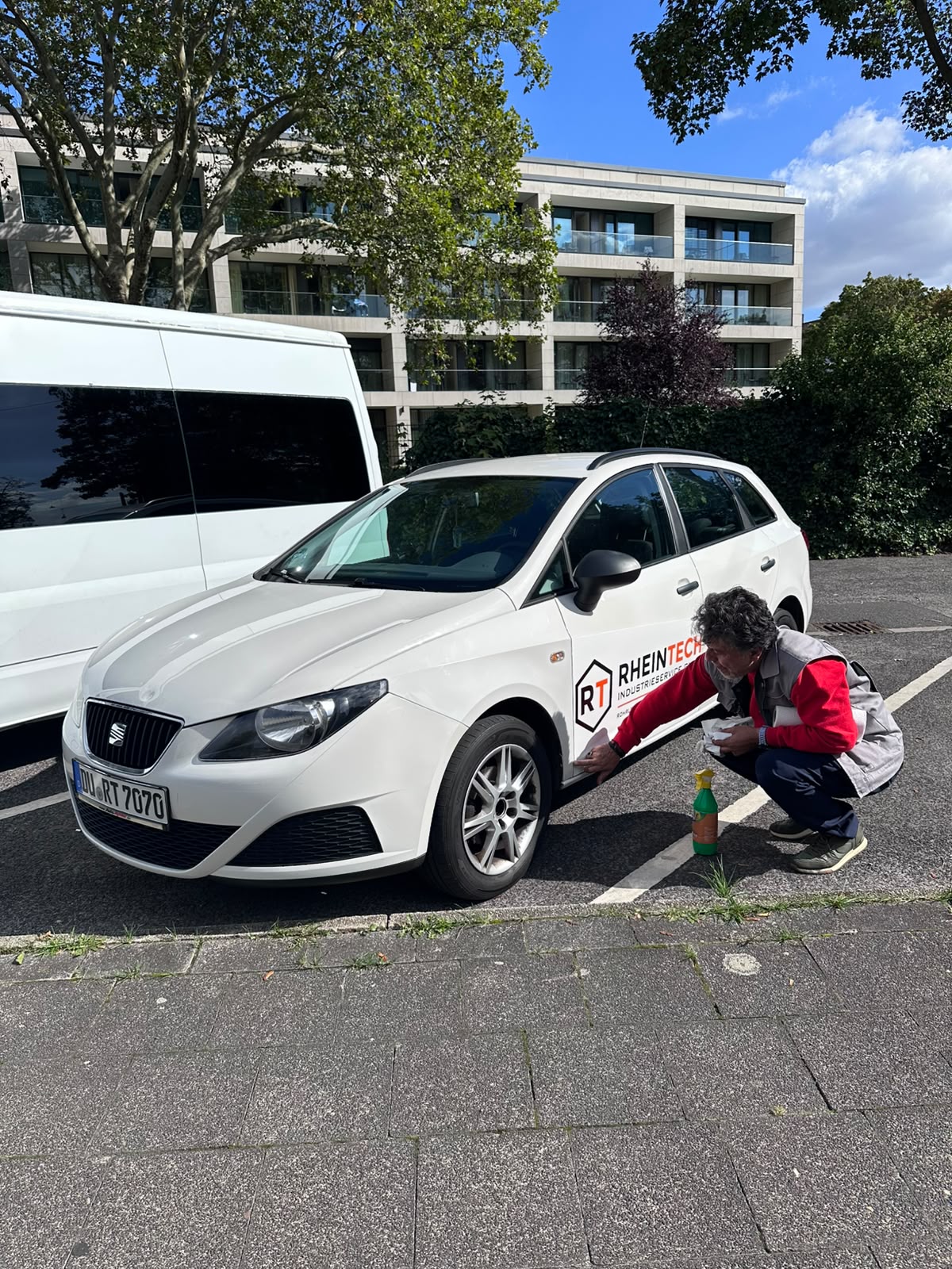 Monteur beim Anbringen einer Fahrzeugfolie mit Firmenlogo